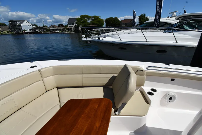 Slide: The Image of 2019 Pursuit S 408 Sport boat interior with beige seating and wooden table. - 49