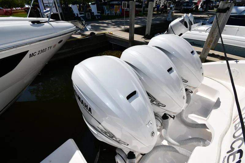 Slide: The Image of Triple Yamaha outboard engines on a 2019 Pursuit S 408 Sport boat at a dock. - 9