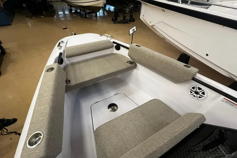 Slide: The Image of 2025 Axopar 22 Spyder boat interior with cushioned seating and cup holders. - 12