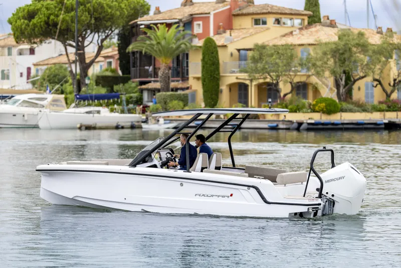 Slide: The Image of 2025 Axopar 22 Spyder boat interior with Mercury engine and seating area. - 2
