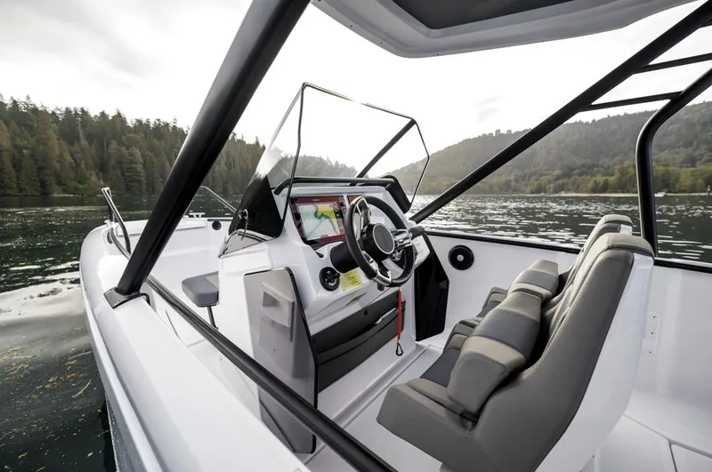 Slide: The Image of 2025 Axopar 22 Spyder boat interior with cushioned seating and central table. - 5
