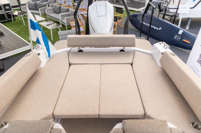 Slide: The Image of 2025 Axopar 22 Spyder boat interior with beige seating and modern design. - 9