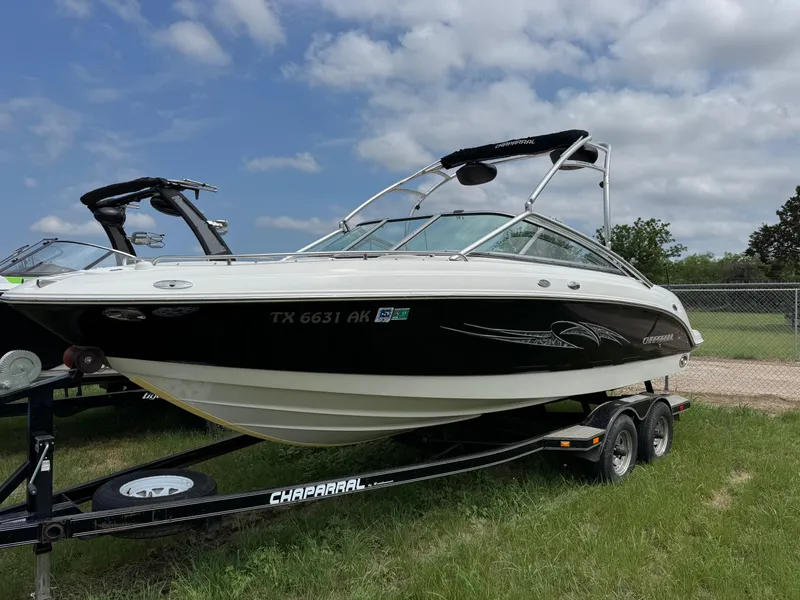 Slide: The Image of 2007 Chaparral 236 SSi boat on trailer, black and white design, parked on grass. - 1