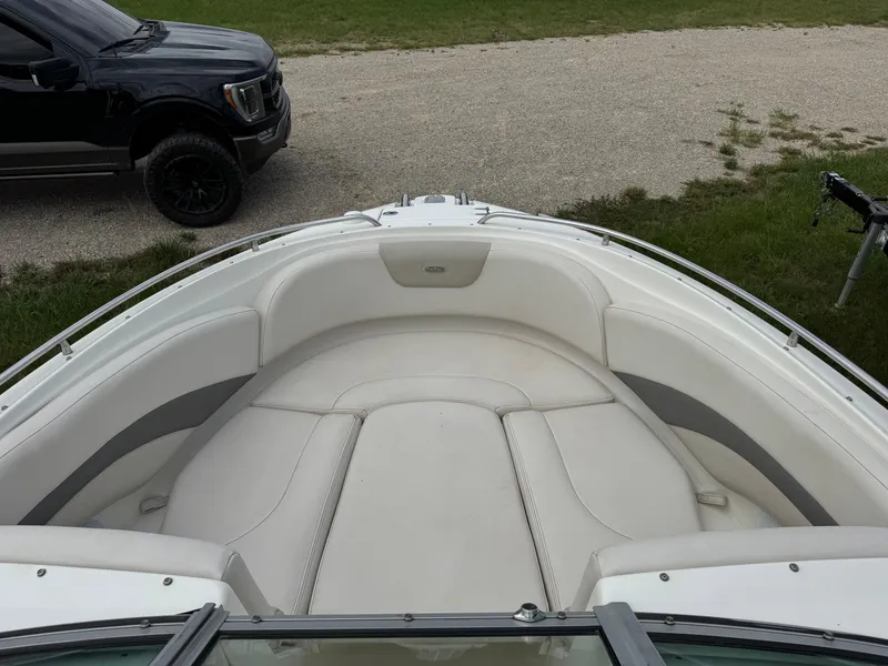 Slide: The Image of 2007 Chaparral 236 SSi boat interior with white seating and a parked vehicle nearby. - 13