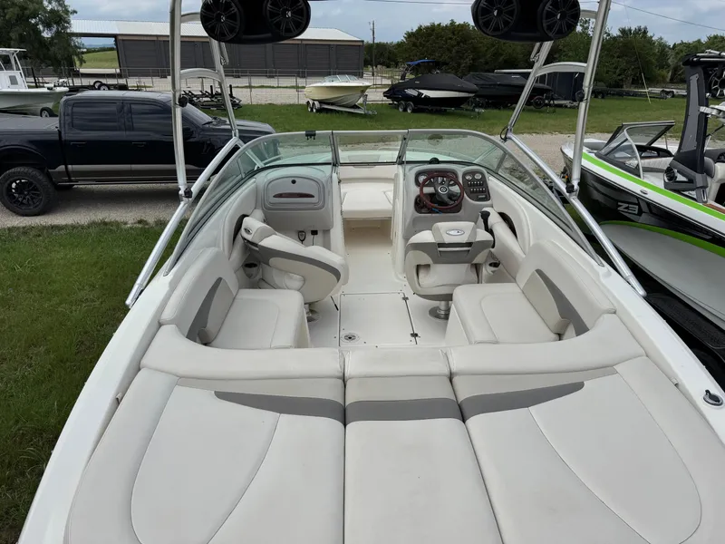 Slide: The Image of 2007 Chaparral 236 SSi boat interior with seating and dashboard, parked outdoors. - 7