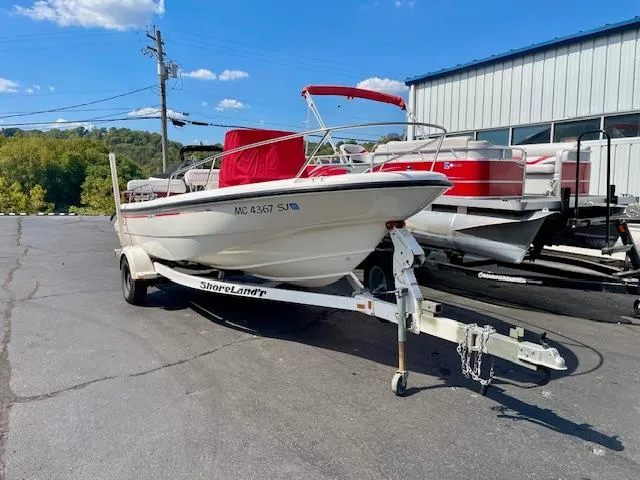 Slide: The Image of 2001 Boston Whaler 18 Dauntless boat on trailer, parked outdoors under blue sky. - 2