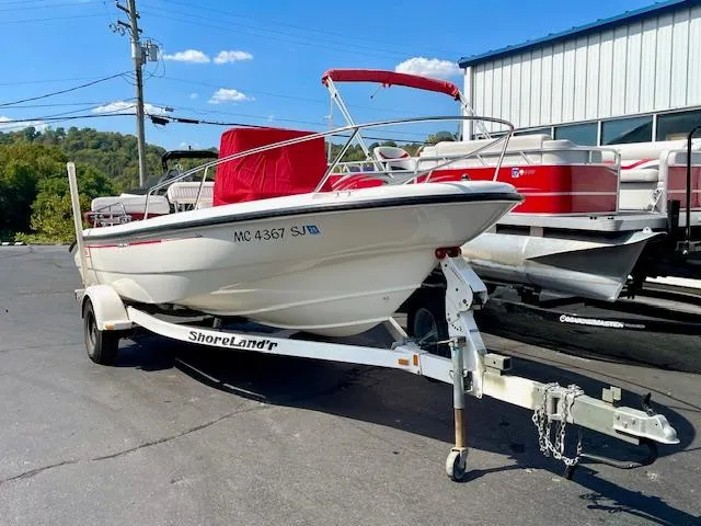 Slide: The Image of 2001 Boston Whaler 18 Dauntless boat on trailer, red canopy, parked outdoors. - 3