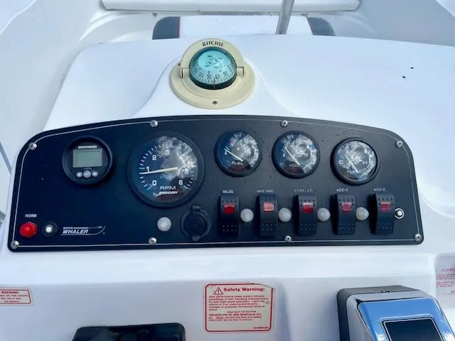 Slide: The Image of Control panel of a 2001 Boston Whaler 18 Dauntless boat with gauges and compass. - 6