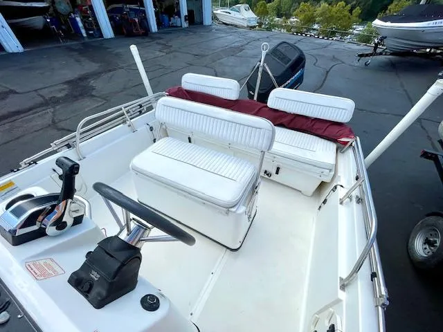 Slide: The Image of 2001 Boston Whaler 18 Dauntless boat interior with white seating and steering console. - 9