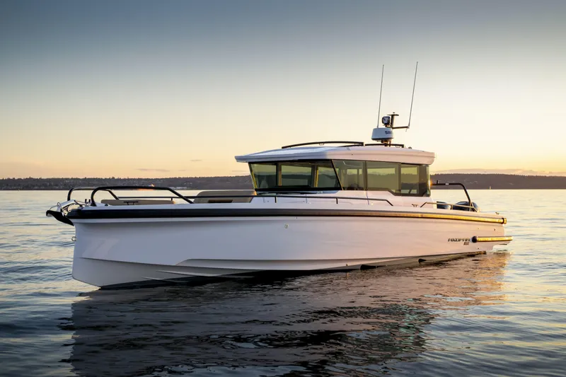 Slide: The Image of 2025 Axopar 37 XC CROSS CABIN boat on calm water at sunset. - 0