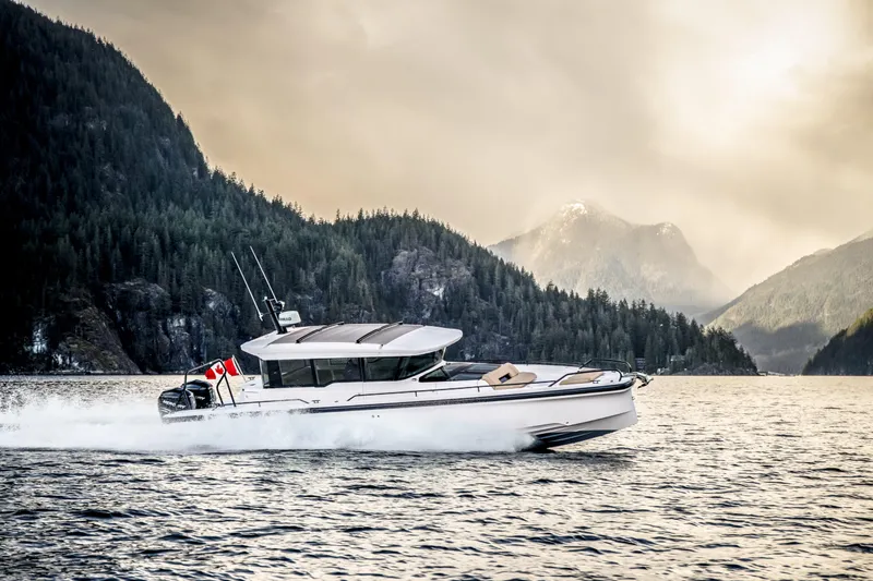 Slide: The Image of 2025 Axopar 37 XC CROSS CABIN cruising in scenic mountainous waters. - 11