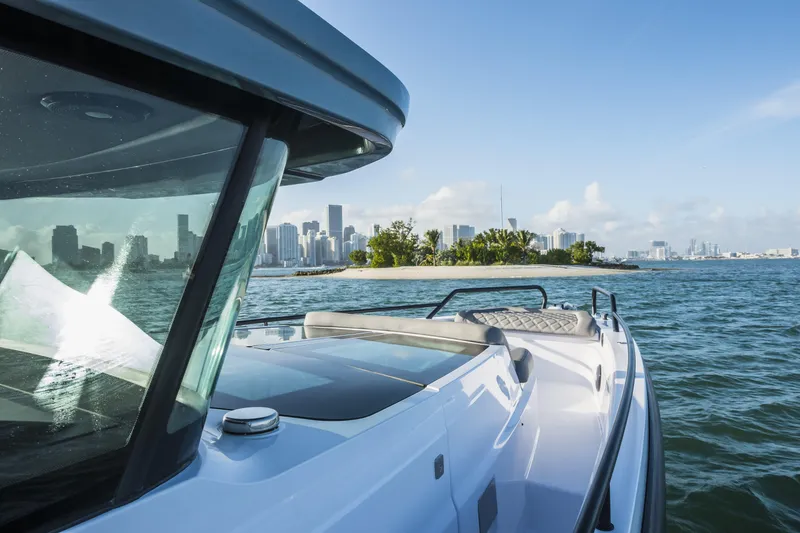 Slide: The Image of 2025 Axopar 37 XC CROSS CABIN cruising near a city skyline on a sunny day. - 18