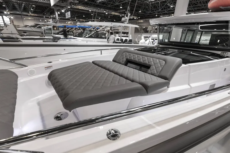 Slide: The Image of 2025 Axopar 37 XC CROSS CABIN with luxurious seating in a showroom. - 19