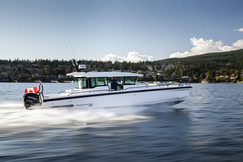 Slide: The Image of 2025 Axopar 37 XC CROSS CABIN cruising on a scenic lake with forested hills. - 9