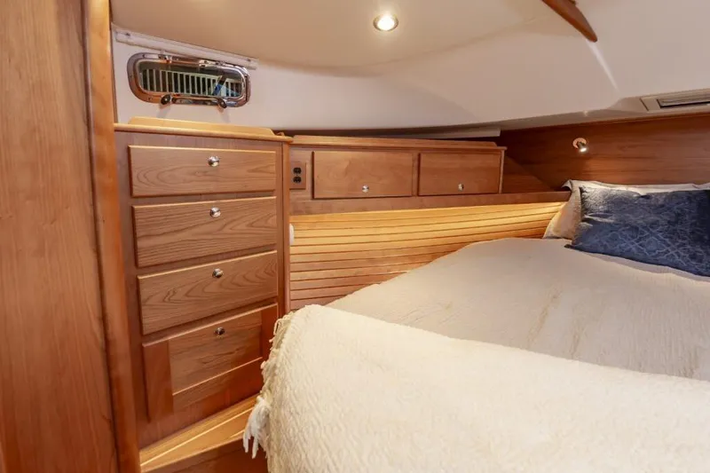 Slide: The Image of Luxurious cabin interior of 2026 Sabre 43 Salon Express with wooden cabinetry and cozy bedding. - 16