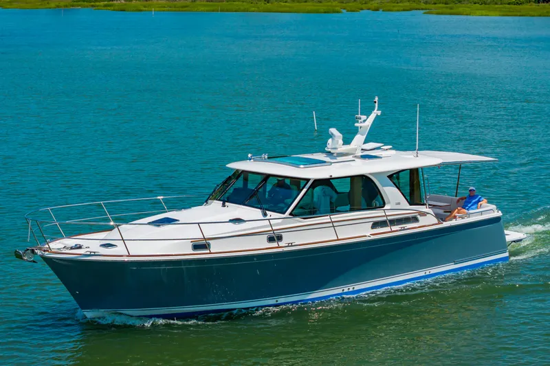 Slide: The Image of 2026 Sabre 43 Salon Express cruising on clear blue water. - 8