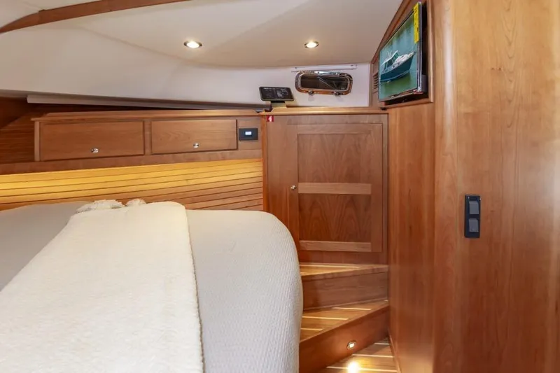 Slide: The Image of Interior of 2026 Sabre 43 Salon Express yacht with wooden cabinetry and cozy bedding. - 18
