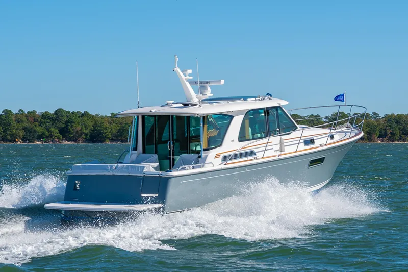 Slide: The Image of 2026 Sabre 43 Salon Express cruising on a sunny day, surrounded by water and trees. - 2