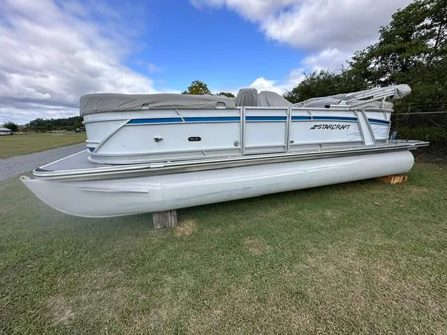 The Image of 2023 Starcraft SLS 3 pontoon boat on grass, under cloudy sky. - 0