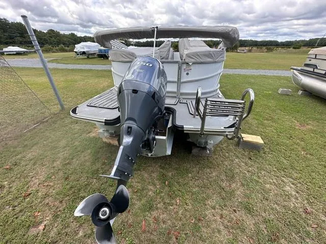 Slide: The Image of 2023 Starcraft SLS 3 boat with outboard motor on grassy area. - 2