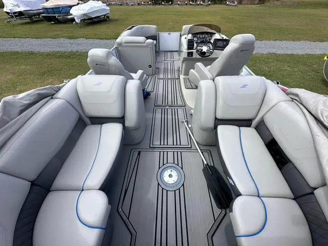 Slide: The Image of 2023 Starcraft SLS 3 pontoon boat interior with plush seating and modern dashboard. - 4