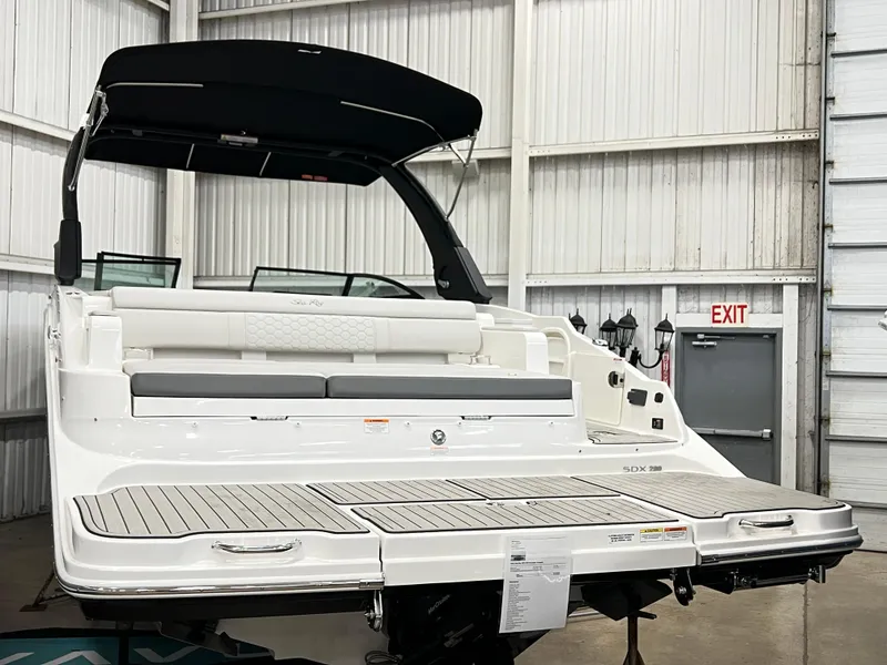 Slide: The Image of 2025 Sea Ray SDX 290 boat in a showroom, rear view with swim platform. - 2