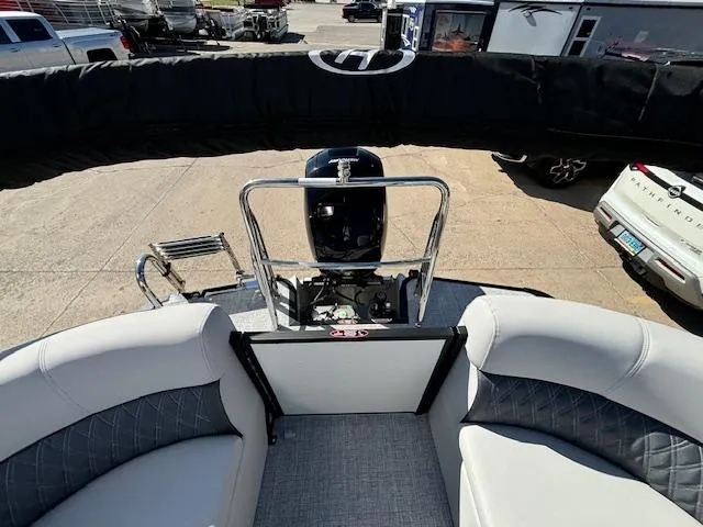 Slide: The Image of 2024 Harris Sunliner 230 CWDH boat interior with seating and motor view. - 13