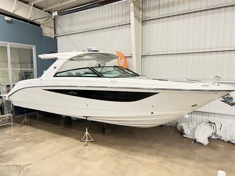 The Image of 2025 Sea Ray SLX 400 boat in a showroom, sleek white design. - 0