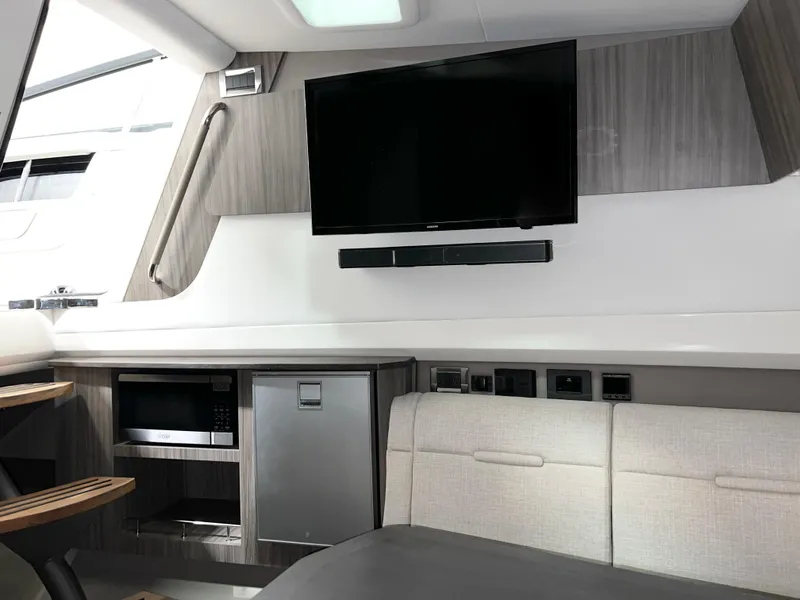 Slide: The Image of Interior of 2025 Sea Ray SLX 400 yacht with TV, microwave, and seating area. - 15