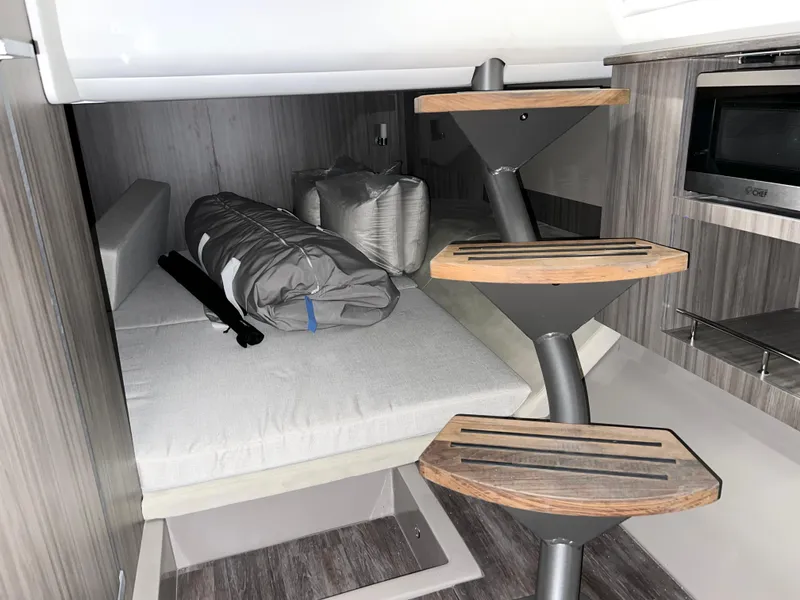 Slide: The Image of 2025 Sea Ray SLX 400 cabin interior with modern staircase and bedding. - 16
