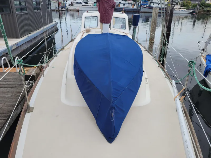 Slide: The Image of 1967 Spencer 42 sailboat with blue cover docked at marina. - 11