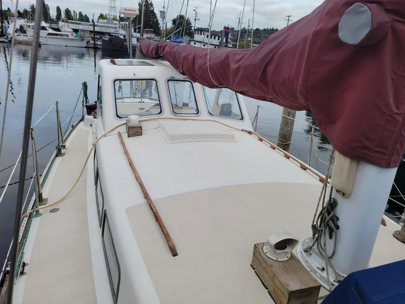 Slide: The Image of 1967 Spencer 42 sailboat docked in marina, featuring maroon sail cover. - 12