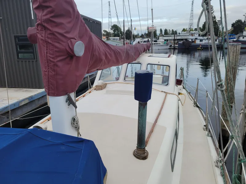 Slide: The Image of 1967 Spencer 42 sailboat docked at marina, featuring maroon sail cover. - 13