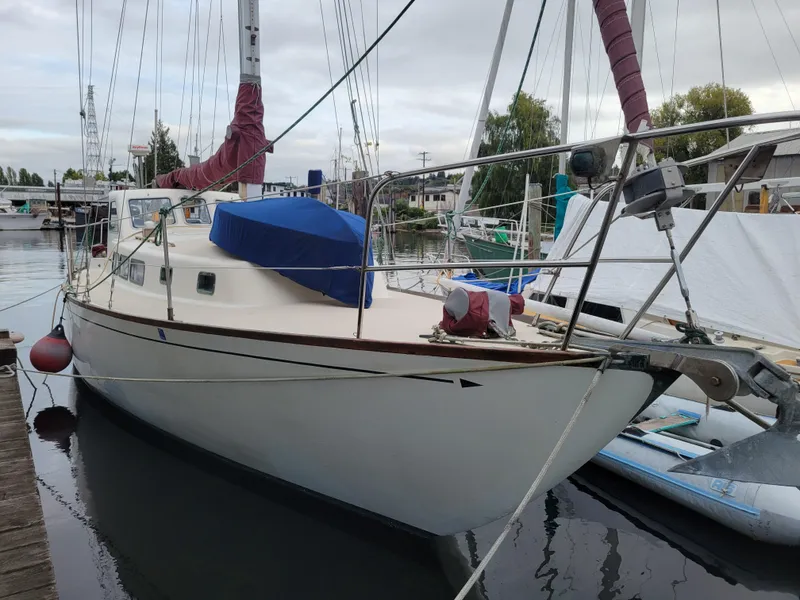 Slide: The Image of 1967 Spencer 42 sailboat docked in a marina, featuring red sails and a blue cover. - 2