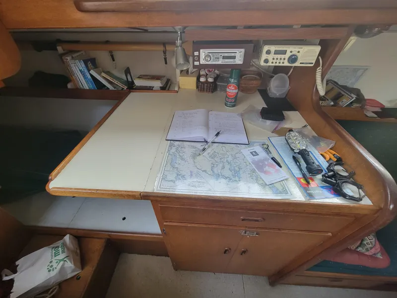 Slide: The Image of Navigation desk on a 1967 Spencer 42 sailboat with maps, radio, and tools. - 21