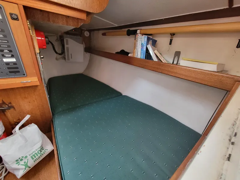 Slide: The Image of Cozy cabin interior of a 1967 Spencer 42 sailboat with green cushions and wooden shelves. - 22