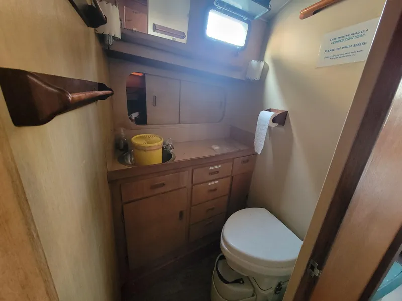 Slide: The Image of 1967 Spencer 42 boat bathroom with wooden cabinets and compact toilet. - 25