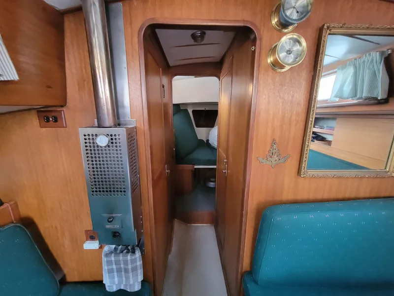 Slide: The Image of Vintage 1967 Spencer 42 yacht interior with wood paneling and green seating. - 33