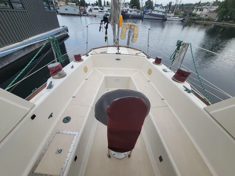 Slide: The Image of 1967 Spencer 42 sailboat cockpit with maroon covers, docked in a marina. - 49