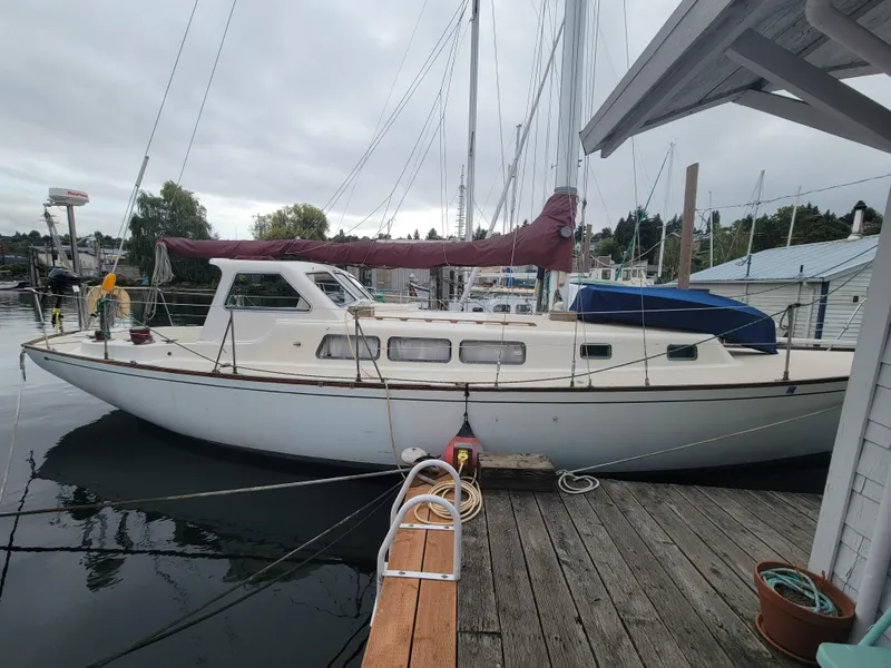 Slide: The Image of 1967 Spencer 42 sailboat docked at a marina, featuring a white hull and maroon sail cover. - 5