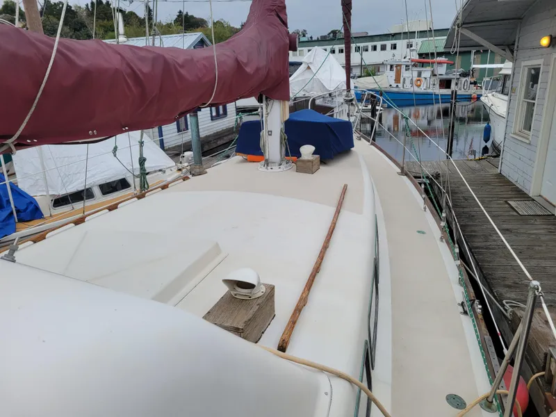 Slide: The Image of 1967 Spencer 42 sailboat docked at marina, featuring maroon sail cover and wooden deck details. - 8