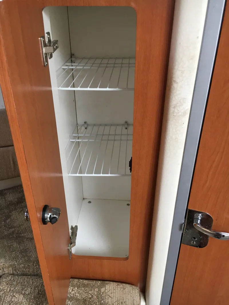 Slide: The Image of 2006 Seaswirl Striper 2901 Walkaround O/B cabinet with wire shelves and wooden door. - 33