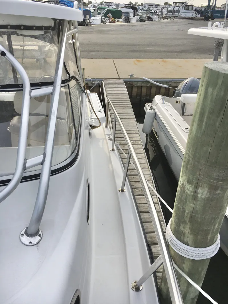 Slide: The Image of 2006 Seaswirl Striper 2901 Walkaround O/B docked at marina, side view. - 6