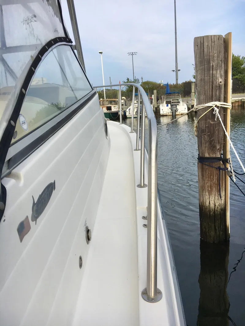 Slide: The Image of 2006 Seaswirl Striper 2901 Walkaround O/B docked, showcasing sleek side railing and marina view. - 8