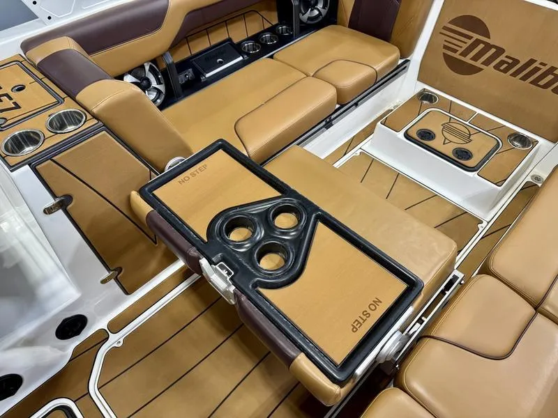 Slide: The Image of 2021 Malibu 25 LSV boat interior with tan leather seats and cup holders. - 11