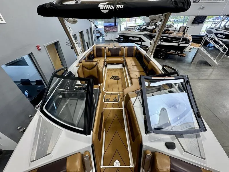 Slide: The Image of 2021 Malibu 25 LSV boat interior with luxurious tan seating and sleek design. - 13