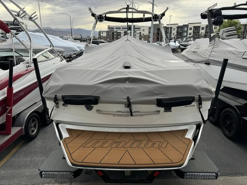 Slide: The Image of 2021 Malibu 25 LSV boat with cover, docked in a marina. - 19
