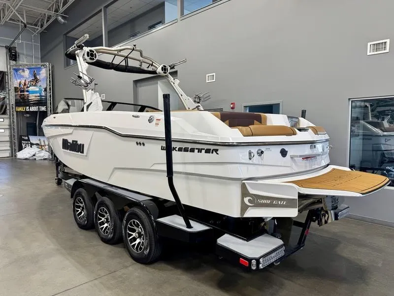 Slide: The Image of 2021 Malibu 25 LSV boat on trailer in showroom, white exterior, luxury design. - 3