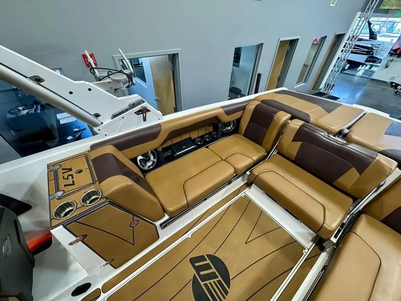 Slide: The Image of 2021 Malibu 25 LSV boat interior with tan and brown seating. - 7