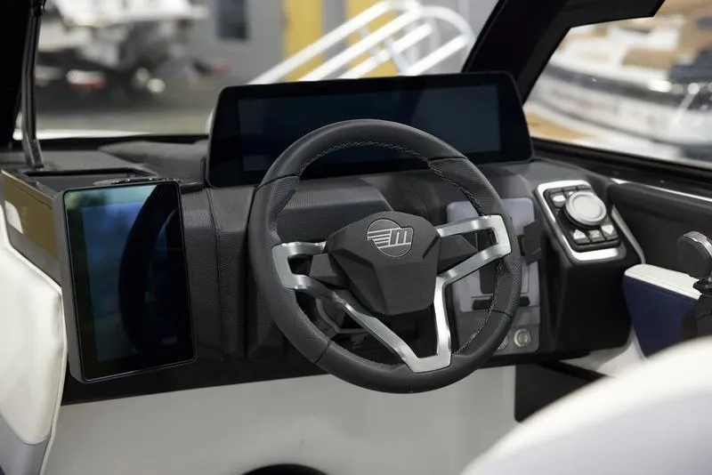 Slide: The Image of 2025 Malibu 22 LSV boat dashboard with modern steering wheel and digital displays. - 11